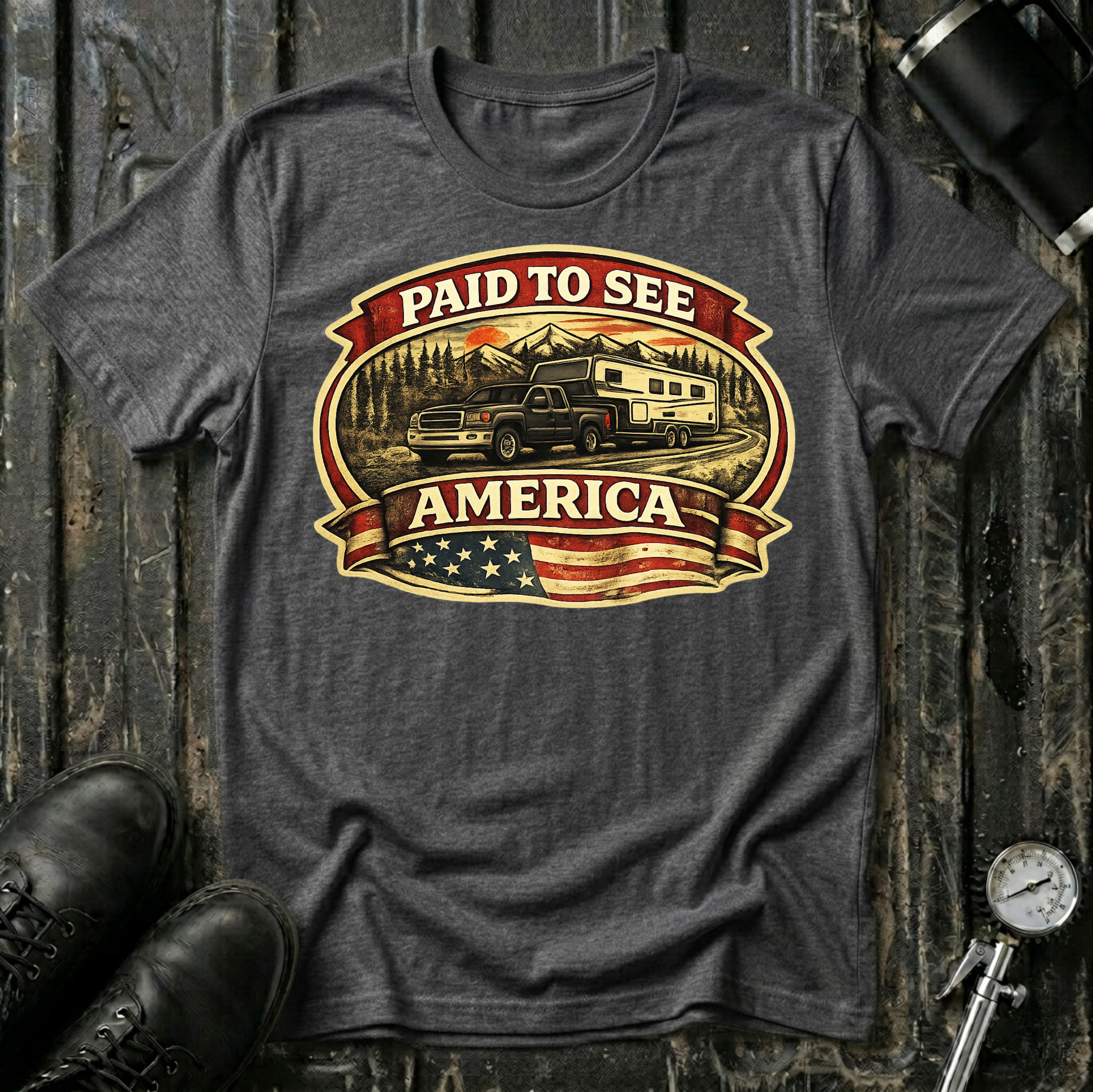 Paid to See America dark truck T-shirt by The Riverstone Life on a dark heather Gildan Softstyle 64000 featuring a pickup truck hauling a fifth-wheel with an American flag and scenic landscape.