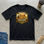 Professional Truck Stop Food Critic T-shirt by The Riverstone Life on a black Gildan Softstyle 64000 featuring a humorous truck stop meal design with classic roadside foods.