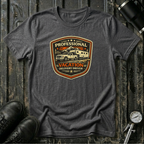Dark heather RV Transport T-shirt featuring a light pickup truck towing a camper with the phrase "Professional Vacation Delivery Driver" in a vintage badge design.