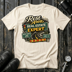 Rest Area Real Estate Expert T-shirt by The Riverstone Life featuring a natural Gildan Softstyle 64000 featuring a humorous highway and rest area design for RV Transport drivers and road travelers.