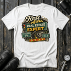 Rest Area Real Estate Expert T-shirt by The Riverstone Life featuring a white Gildan Softstyle 64000 featuring a humorous highway and rest area design for RV Transport drivers and road travelers.