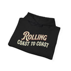 A folded black hoodie with 'Rolling Coast to Coast' printed on the front in a cream and red retro font, shown on a plain white background.