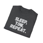 A folded dark gray t-shirt with the phrase 'SLEEP, TOW, REPEAT.' printed in a bold, distressed white grayish font, displayed on a clean white background.