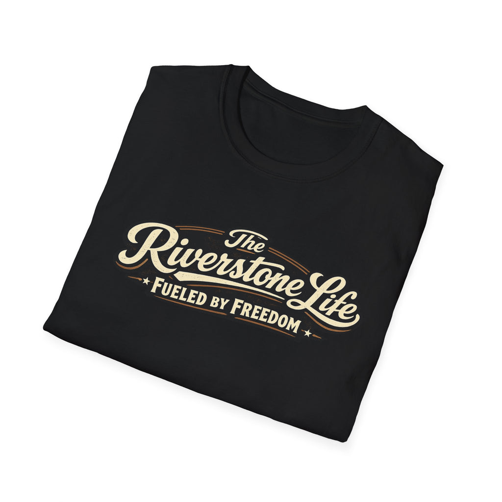 A black folded t-shirt with a vintage-style cream and gold graphic reading 'The Riverstone Life FUELED BY FREEDOM' on a clean white background.