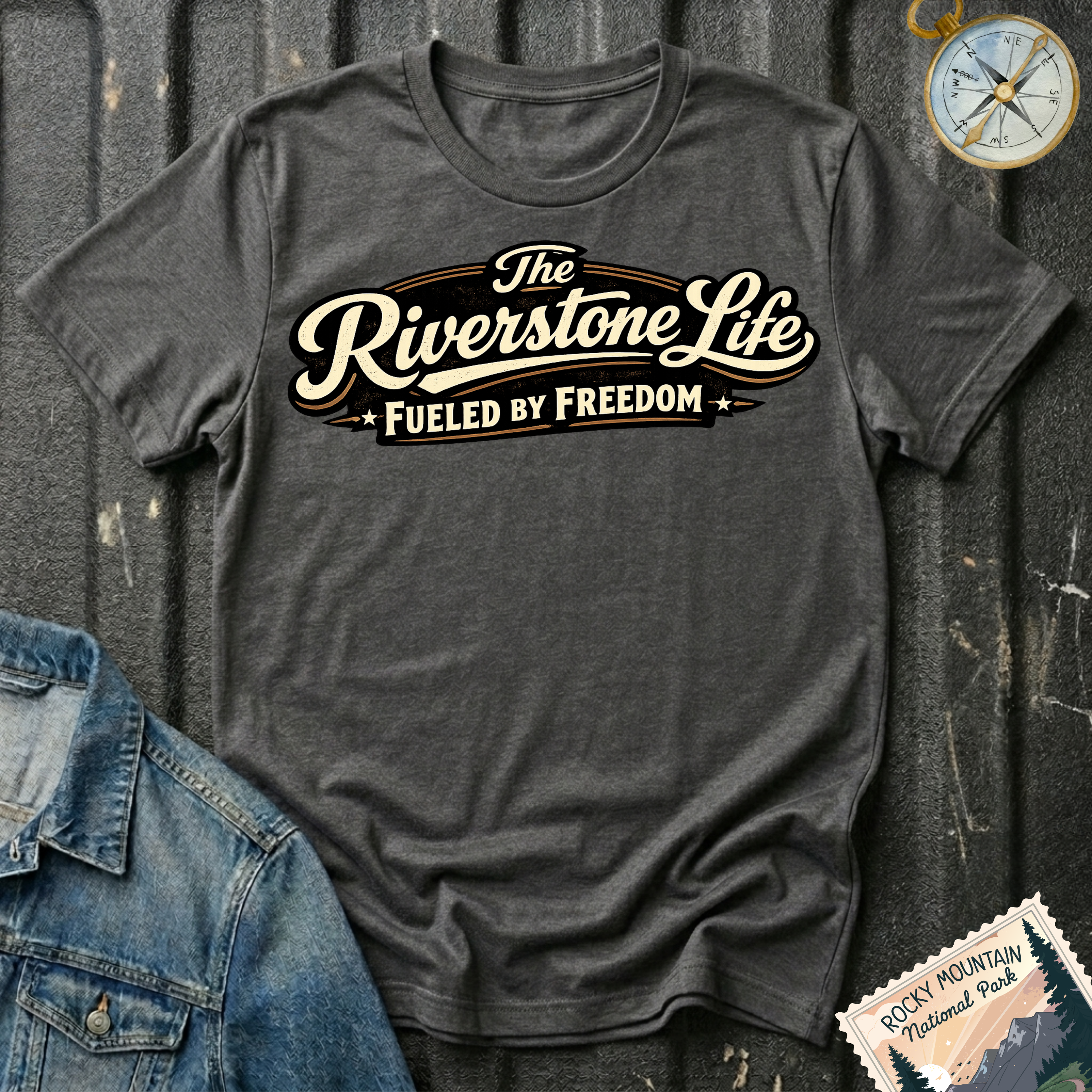 The Riverstone Life–Fueled by Freedom T-shirt on a dark heather Gildan Softstyle 64000 featuring the official The Riverstone Life logo.