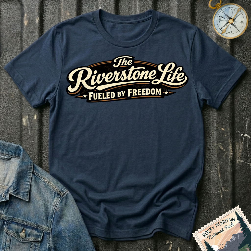 The Riverstone Life–Fueled by Freedom T-shirt on a navy Gildan Softstyle 64000 featuring the official The Riverstone Life logo.