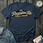 The Riverstone Life–Fueled by Freedom T-shirt on a navy Gildan Softstyle 64000 featuring the official The Riverstone Life logo.