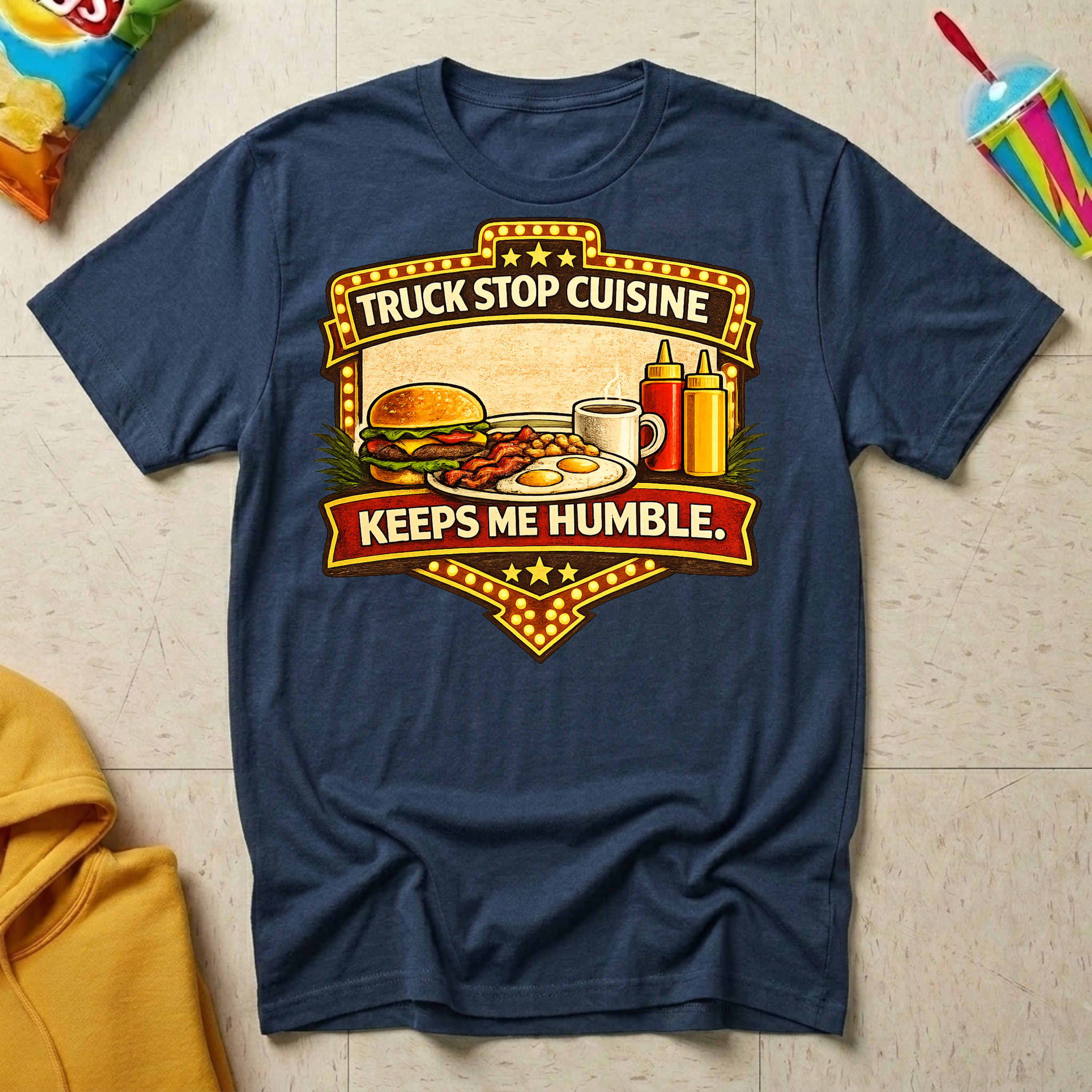 Truck Stop Cuisine Keeps Me Humble T-shirt by The Riverstone Life on a navy Gildan Softstyle 64000 featuring a vintage truck stop food graphic.