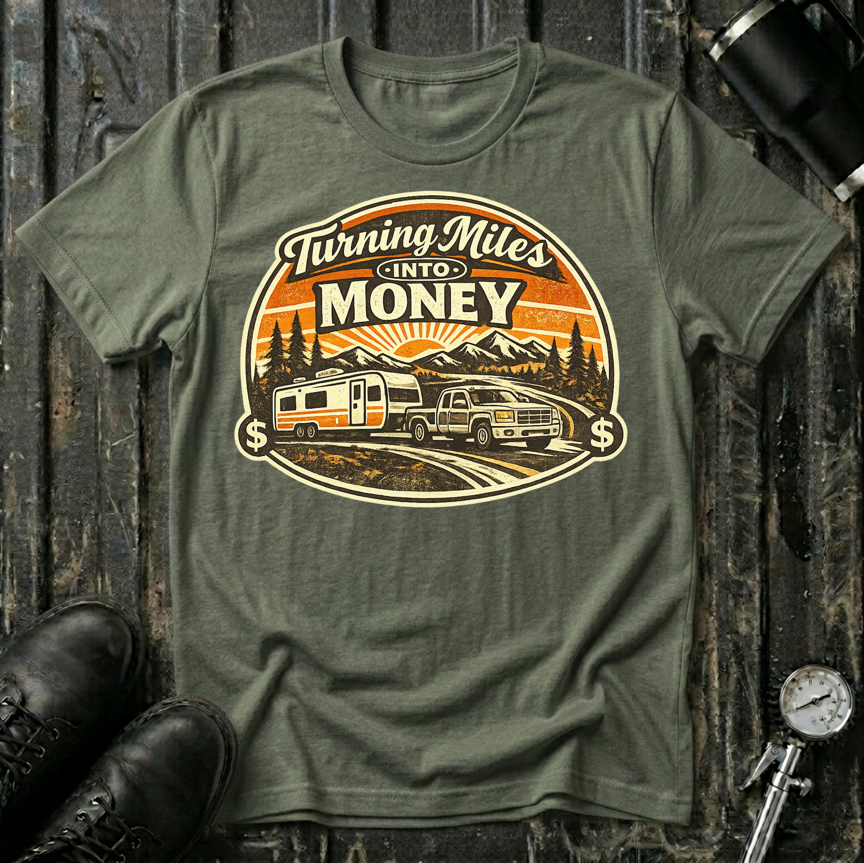Turning Miles Into Money T-Shirt by The Riverstone Life on a military green Gildan Softstyle 64000 featuring a pickup truck hauling an RV through a mountain landscape.