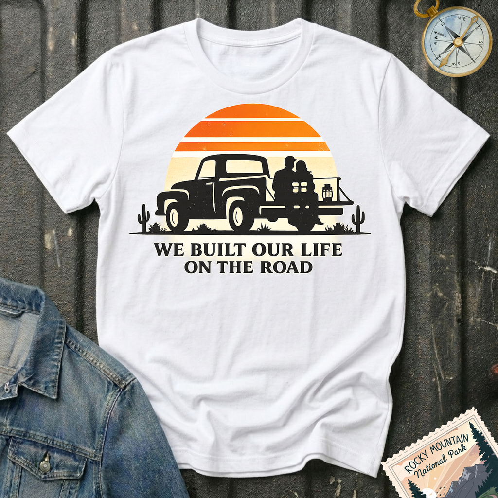We Built Our Life on the Road T-shirt by The Riverstone Life on a white Gildan Softstyle 64000 featuring a vintage pickup truck, couple, retro sunset inspired by RV life and adventure.